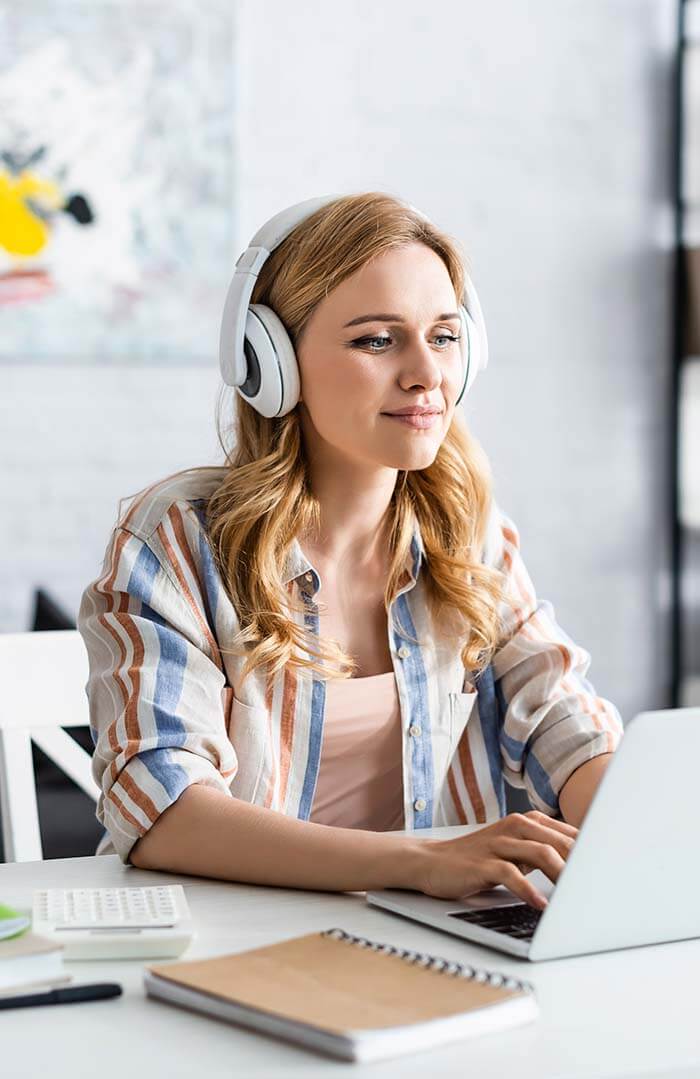 E-Learning - Online Unterweisung - Rau Arbeitsschutz Person mit Kopfhörern am Laptop